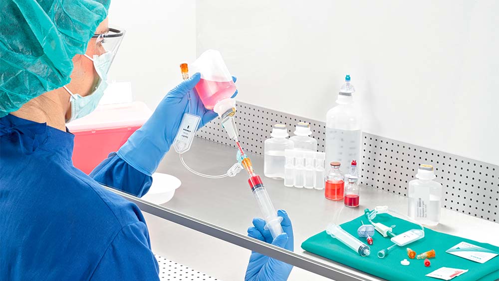 약사가 lamina airflow 아래에서 주사기를 잡아당깁니다.