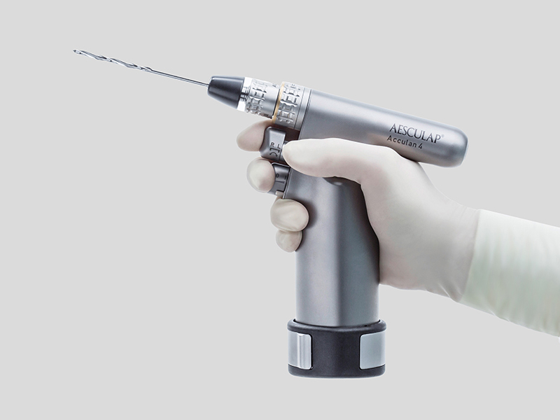 한 손에 장갑을 끼고 있는 수술용 전동 드릴 시스템